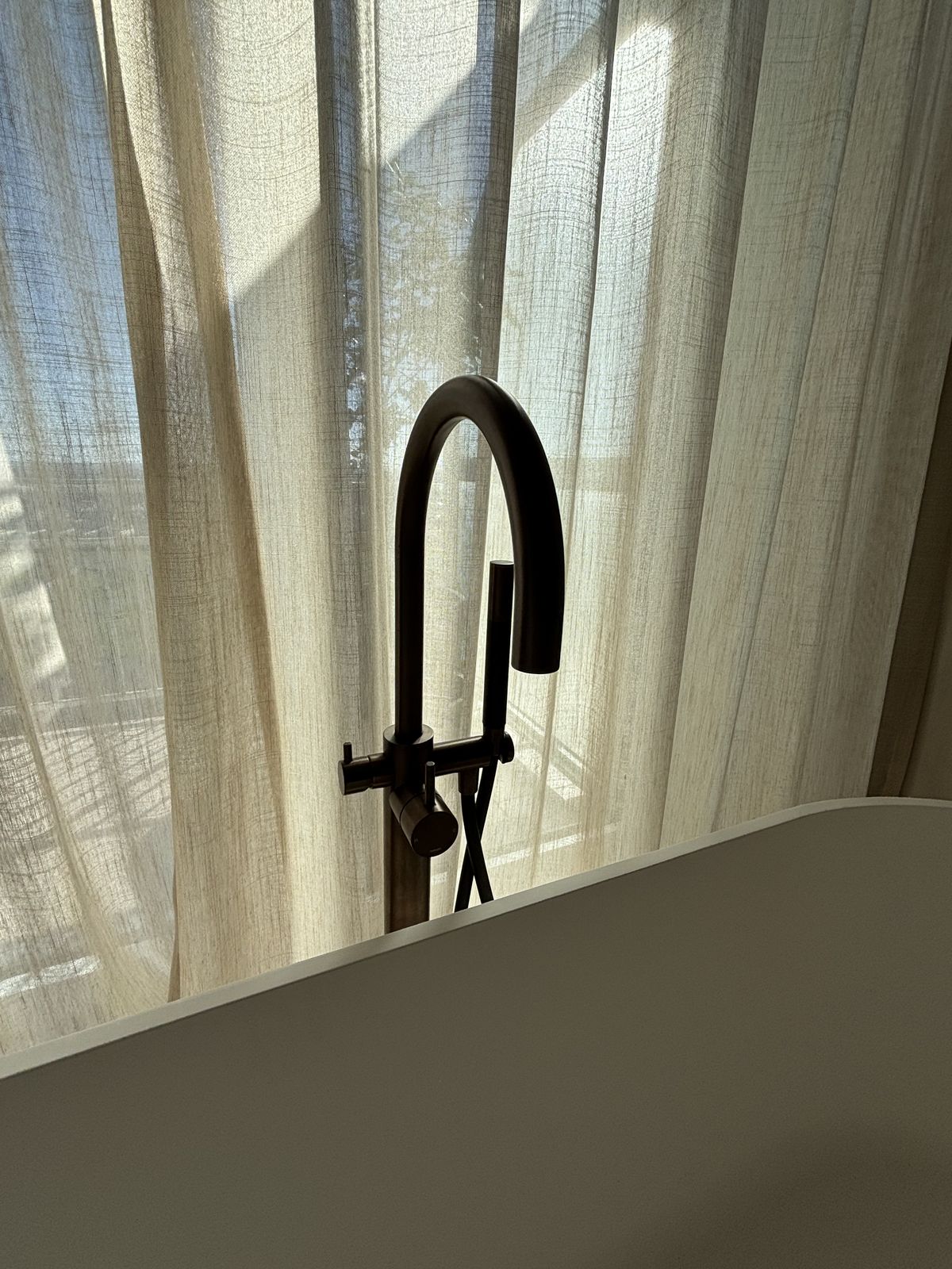 Badkamer met vrijstaand bad en Hotbath-kranen in brushed copper in Oostende