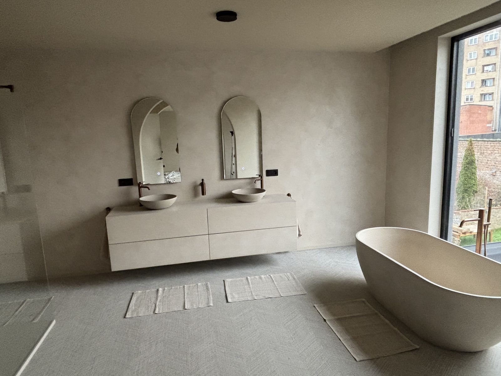 Badkamer met vrijstaand bad en dubbele waskom in Oostende